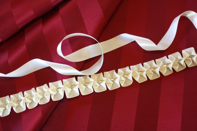 Red satin striped fabric with cream satin ribbon and cream and crystal embellishment.