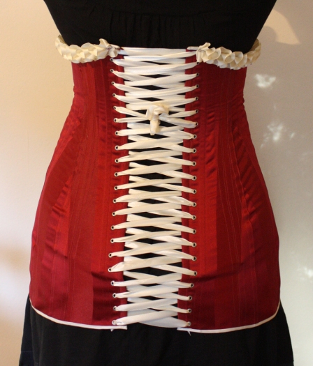 Back of red striped satin 1911 long line corset with cream satin trimmings and cream satin laces